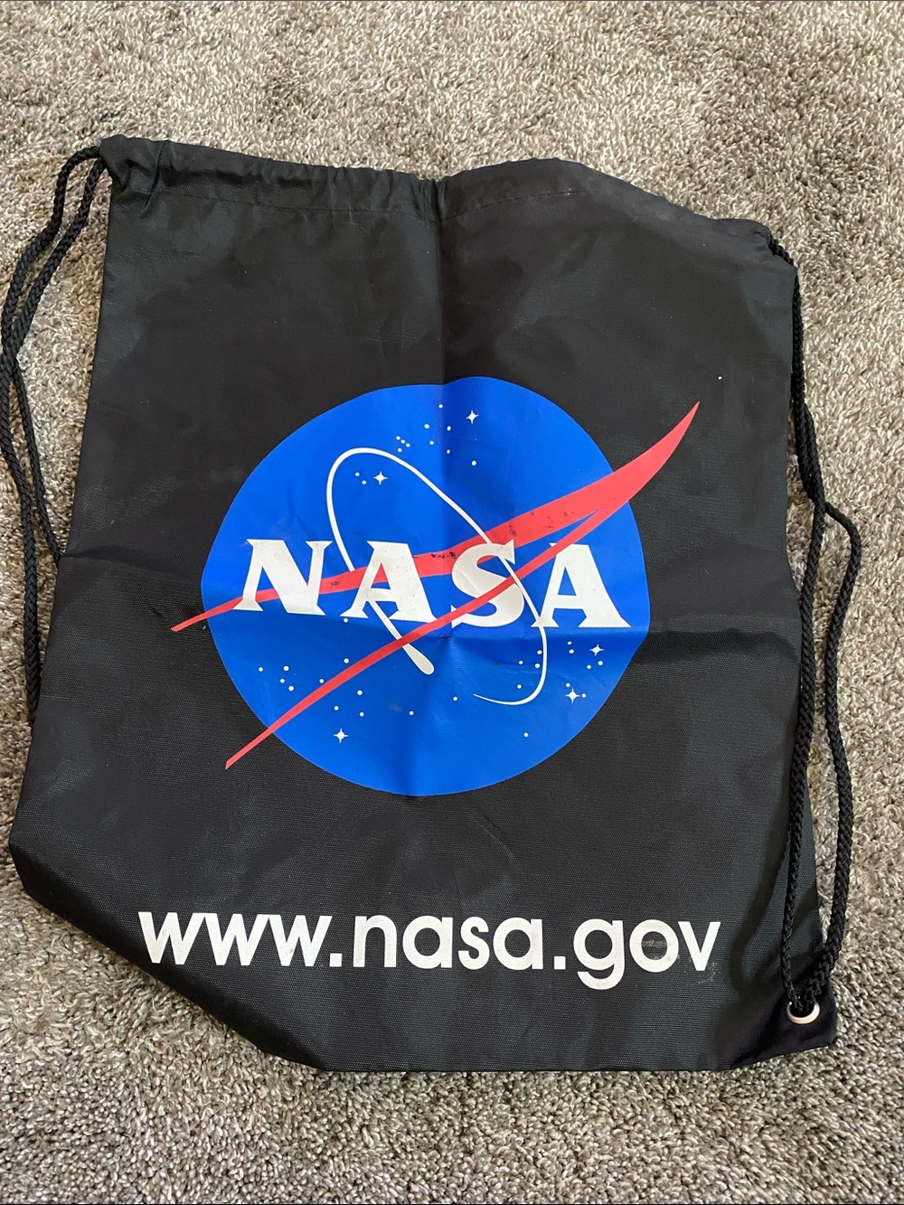 Black drawstring NASA back pack. Lightweight, foldable for easy travel shopping